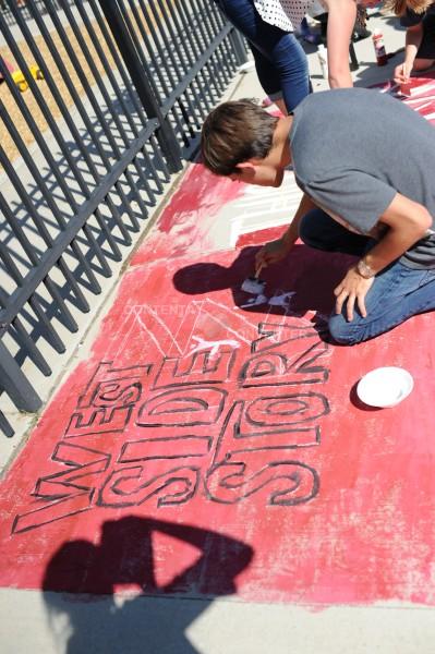 Advanced Theater advertises musical at homecoming street painting event.